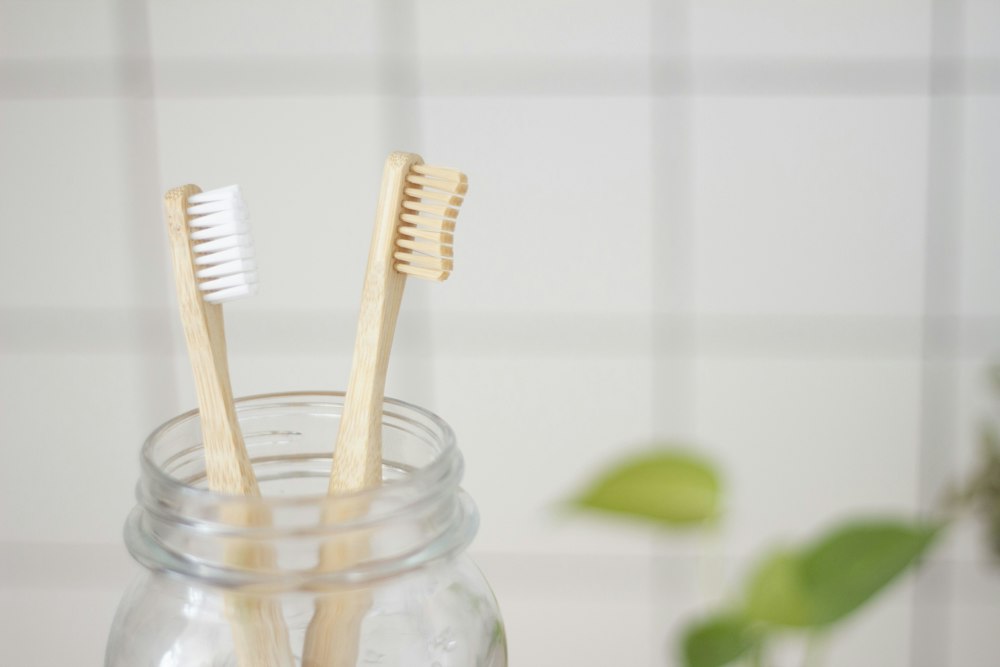 Cepillos de dientes en un frasco de vidrio en su comuna